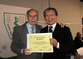 Dr. Tomas Kim entrega o certificado de Sócio Remido ao Dr. Nelson Jacintho