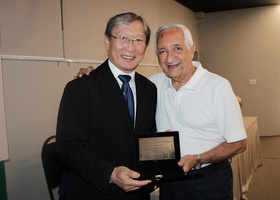 Dr. Marcos Rondon de Assis, presidente do Conselho Fiscal do Centro Médico, representando a família do Profº Dr. Gutemberg de Melo Rocha, recebe o cartão de homenagem do Dr. Tomas Kim, presidente do Centro Médico