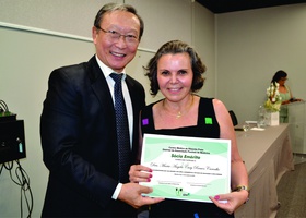 Dr. Tomas Kim entrega certificado de Sócia Emérita à Dra. Maria Ângela Cury Ramos Carvalho