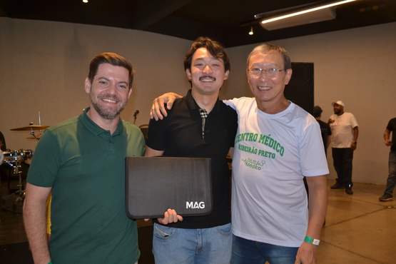 Daniel Petelinkar, da MAG Seguros, entrega brinde a Alberto Kim ao lado do pai,  Dr. Tomas Kim...